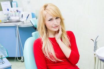 woman holding jaw during dental emergency