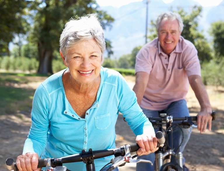 older couple riding bikes with proud smiles in mirrabooka
