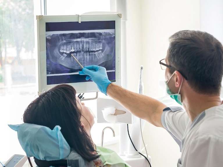 dentist showing dental x-rays to patient in mirrabooka